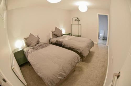 a bedroom with two beds and a hallway at St Edmunds House in Ipswich