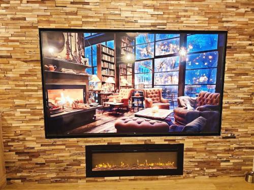 a living room with a tv on a brick wall at La Parenthèse - Votre Cocon au Centre d'Oyonnax in Oyonnax