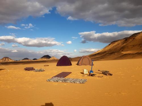 a desert with two tents in the sand at White Desert trip in Az Zabū