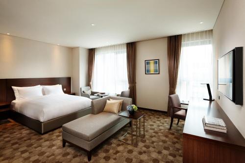 a hotel room with a bed and a living room at LOTTE City Hotel Ulsan in Ulsan