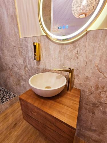 a bathroom with a bowl sink on a wooden counter at La Parenthèse - Votre Cocon au Centre d'Oyonnax in Oyonnax