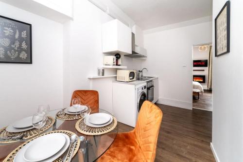 a dining room with a table and chairs and a kitchen at [Covent Garden-Oxford street] Central London Studio Apartment in London