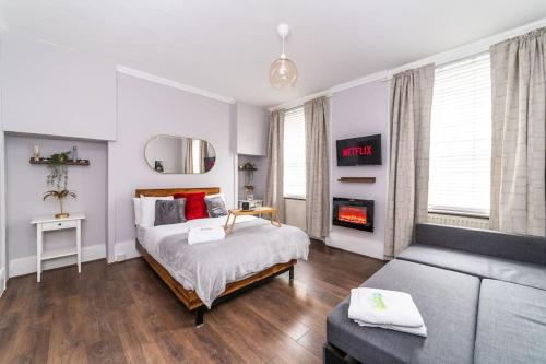 a bedroom with a bed and a couch and a fireplace at [Covent Garden-Oxford street] Central London Studio Apartment in London