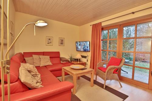 a living room with a red couch and a table at Ferienparadies Klingberg Ferienparadies Klingberg Appartement 1 in Klingberg