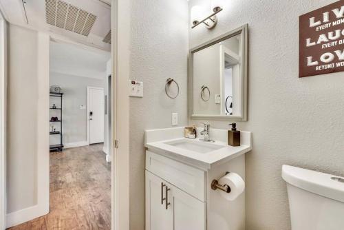 a white bathroom with a sink and a mirror at Near Downtown Dallas - The Dapper Charm in Dallas