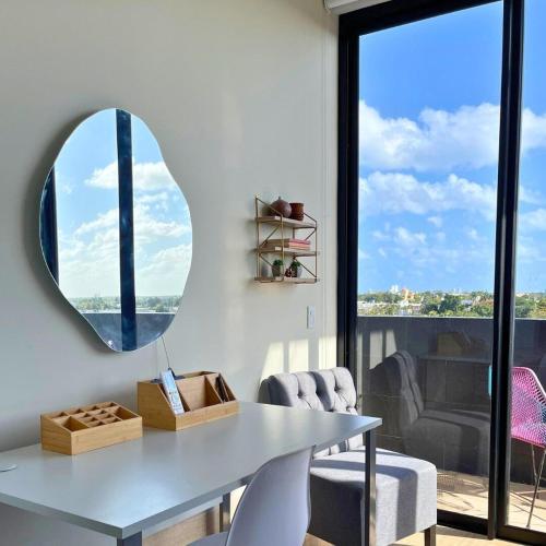 a dining room with a table and a mirror at Brand New Condo with Rooftop Pool in Cozumel