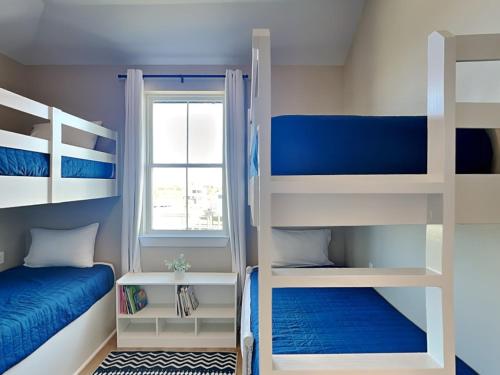 a room with two bunk beds and a window at Pescadors Paradise in Galveston