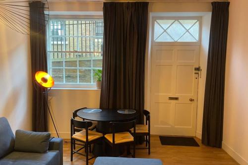 uma sala de estar com uma mesa e uma janela em Spacious 1BD Flat - Next to Richmond Riverside! em Richmond