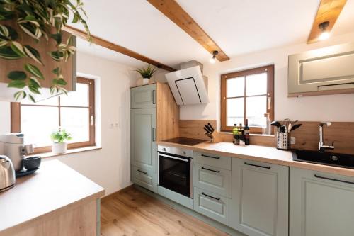 a kitchen with white cabinets and windows in a room at Nächtigen an der Stadtmauer in Rothenburg ob der Tauber