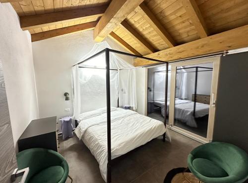 um quarto com uma cama de dossel e um espelho em Appartamenti relax Nus Spa em Nus