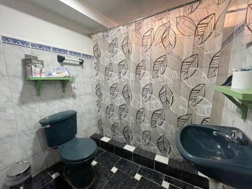 a bathroom with a black toilet and a sink at Casita acogedora en cusco in Cusco