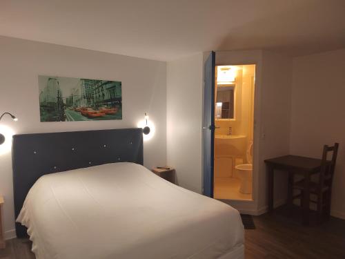 a bedroom with a white bed and a bathroom at FASTHOTEL PARIS OUEST BOUAFLE in Bouafle
