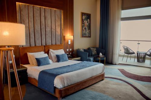 a hotel room with a bed and a large window at Tolip Resort El Galala Hills in Ain Sokhna