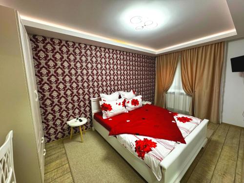 a bedroom with a bed with red sheets and pillows at Boulevard Flat in Alba Iulia