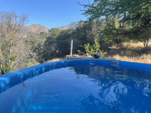 a pool of blue water with mountains in the background at Casa los Boldos in Curacaví