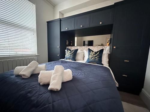 a bedroom with a large blue bed with two pillows at Contemporary stunning flat in Reading