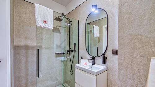 uma casa de banho com um chuveiro, um lavatório e um espelho. em Rezydencja Niechorze 208 z 2 sypialniami i 2 łazienkami przy Plaży - 5D Apartamenty em Niechorze
