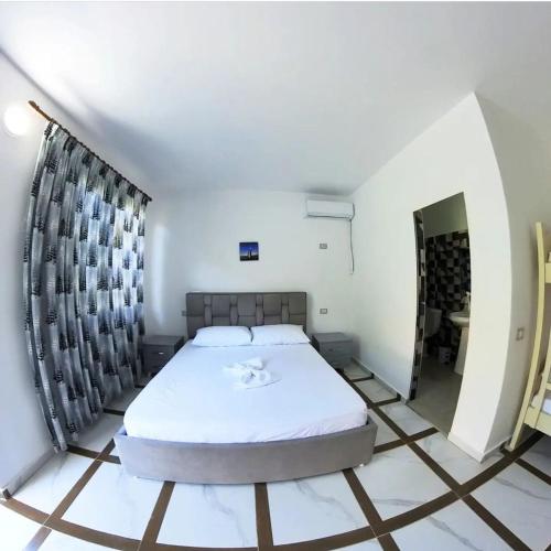 ein Schlafzimmer mit einem Bett in einem Zimmer in der Unterkunft Novruzi Complex in Vlorë