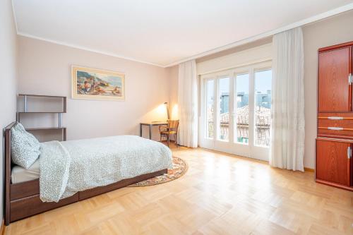 um quarto com uma cama e uma grande janela em Orlando Home em Trieste