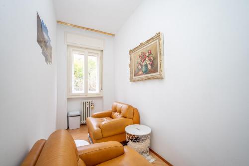 uma sala de estar com um sofá e duas cadeiras em Orlando Home em Trieste