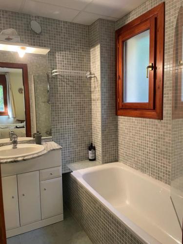 uma casa de banho com uma banheira e um lavatório em Chez Maurice avec une belle vue em El Tarter