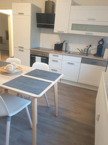 a kitchen with a table and white cabinets at City Apartment in Gelsenkirchen