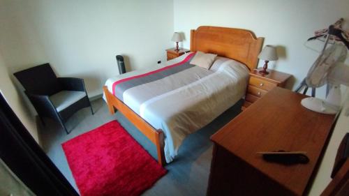 1 dormitorio con cama, escritorio y silla en Cantinho da Fajã, en Faja Grande