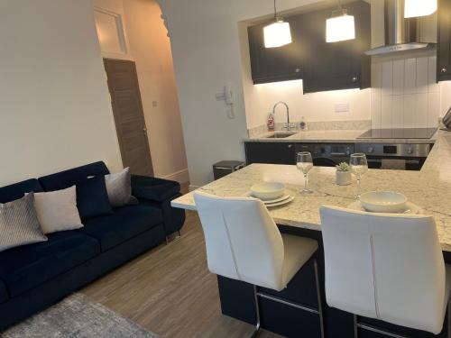 a kitchen and living room with a table and a couch at Contemporary stunning flat in Reading