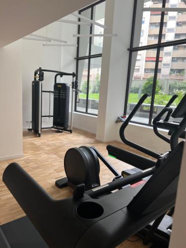 a gym with two treadmills in a room with windows at Number House - Number 9 in Milan