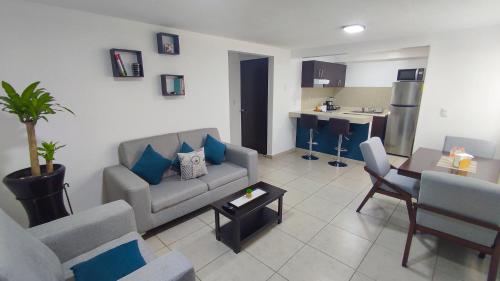 a living room with a couch and a table at Depa Balcones cerca Estadio GNP, Palacio de los Deportes, Autódromo HR y Aeropuerto CDMX in Mexico City