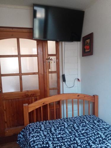 1 dormitorio con 1 cama y TV de pantalla plana en Habitación casa familia en La Serena