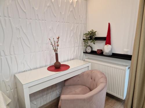a living room with a chair and a white table at Golden Airport Residence in Otopeni