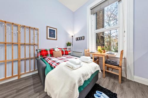 - une chambre avec un lit, un bureau et une fenêtre dans l'établissement Olympia Kensington Stay Studio, à Londres