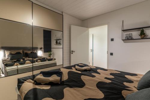 a bedroom with a large bed and a mirror at Nordic Apartment Katajaranta in Rovaniemi