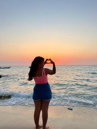 a woman standing on the beach looking at the ocean at AcapulcoBeach in Playa Blanca