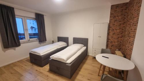Sala de estar con 2 camas y mesa en Kaiserslautern Apartments, en Kaiserslautern