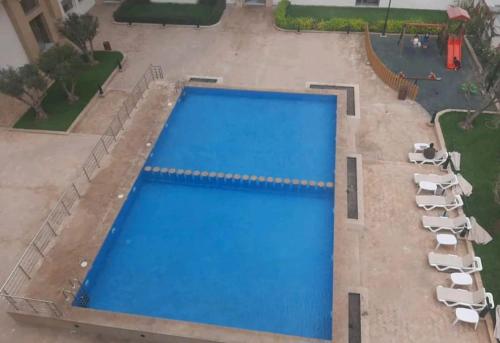 Aïn Harrouda的住宿－Appartement Calme avec Piscine Mohemmadia Zenata，享有带躺椅的大型游泳池的顶部景致