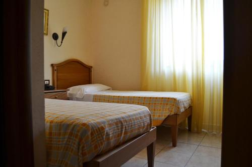a hotel room with two beds and a window at Hotel Ristorante L'Avvenire in Gizzeria