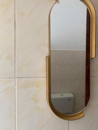 a mirror on a bathroom wall with a toilet at Mkayamba House in Malindi