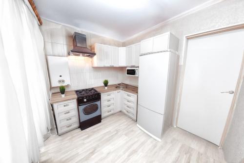 a kitchen with white cabinets and an open door at Староказацкая 60Госпиталь in Dnipro