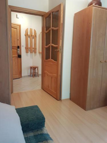 a room with a wooden door and a room with a room at Apartament Crystal in Karpacz