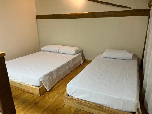 two twin beds in a room with wooden floors at Pousada Dona Carmem Ubatuba in Ubatuba