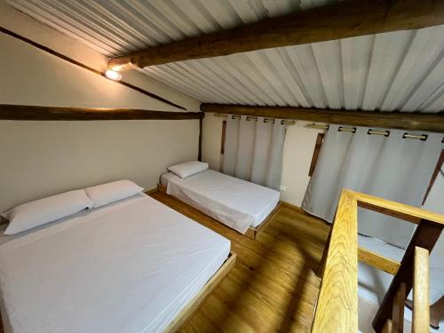 a small room with two beds in it at Pousada Dona Carmem Ubatuba in Ubatuba