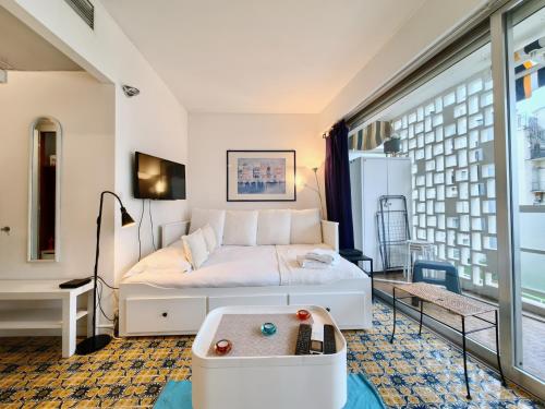 een slaapkamer met een bed en een groot raam bij Studio Royal Lux by Booking Guys in Nice