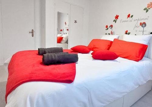 Una gran cama blanca con almohadas rojas. en Éclat Méditerranéen - Côte d'Azur, en Cagnes-sur-Mer