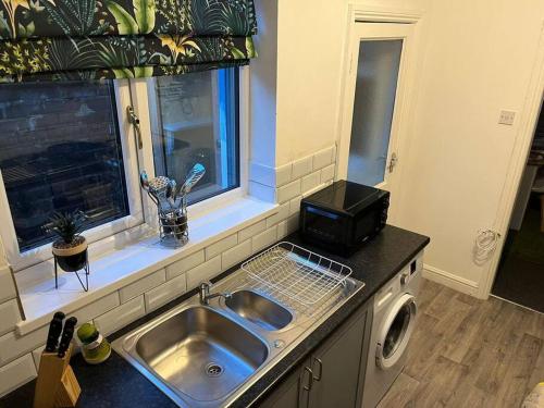 a kitchen with a sink and a window at SkylinesAirbnb in Stoke on Trent