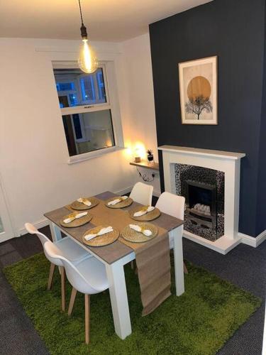a dining room with a table and a fireplace at SkylinesAirbnb in Stoke on Trent