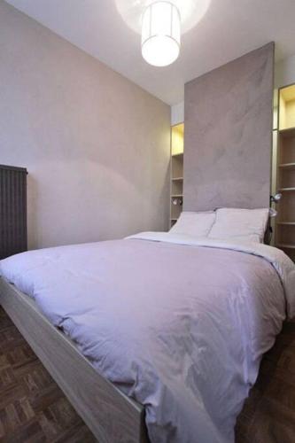 een slaapkamer met een groot bed met witte lakens bij Appartement avec ascenseur LA DÉFENSE in Courbevoie