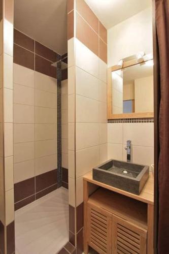 W łazience znajduje się umywalka i prysznic. w obiekcie Appartement avec ascenseur LA DÉFENSE w mieście Courbevoie