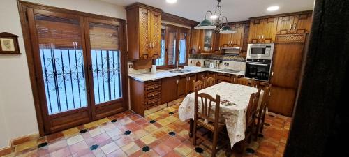 a kitchen with wooden cabinets and a table and chairs at CASITA ROCIO in Jaén